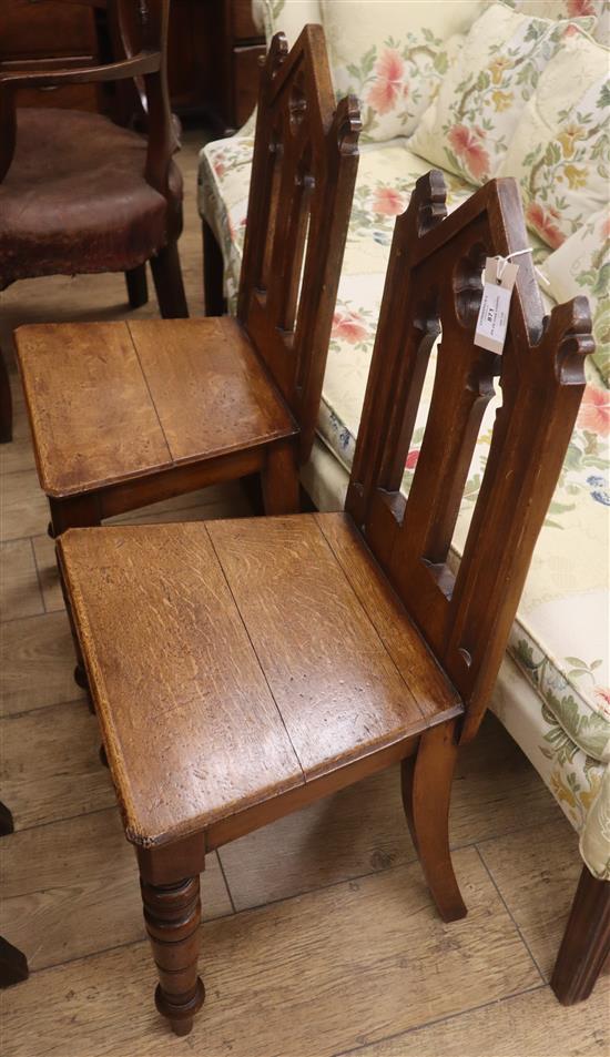 A pair of Victorian Gothic Revival carved oak hall chairs